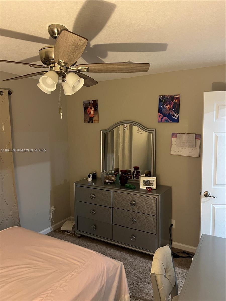 172 Southwest Langfield Avenue Port St. Lucie, FL 34984 - Photo 11 of 24 a bedroom with a bed and a chandelier