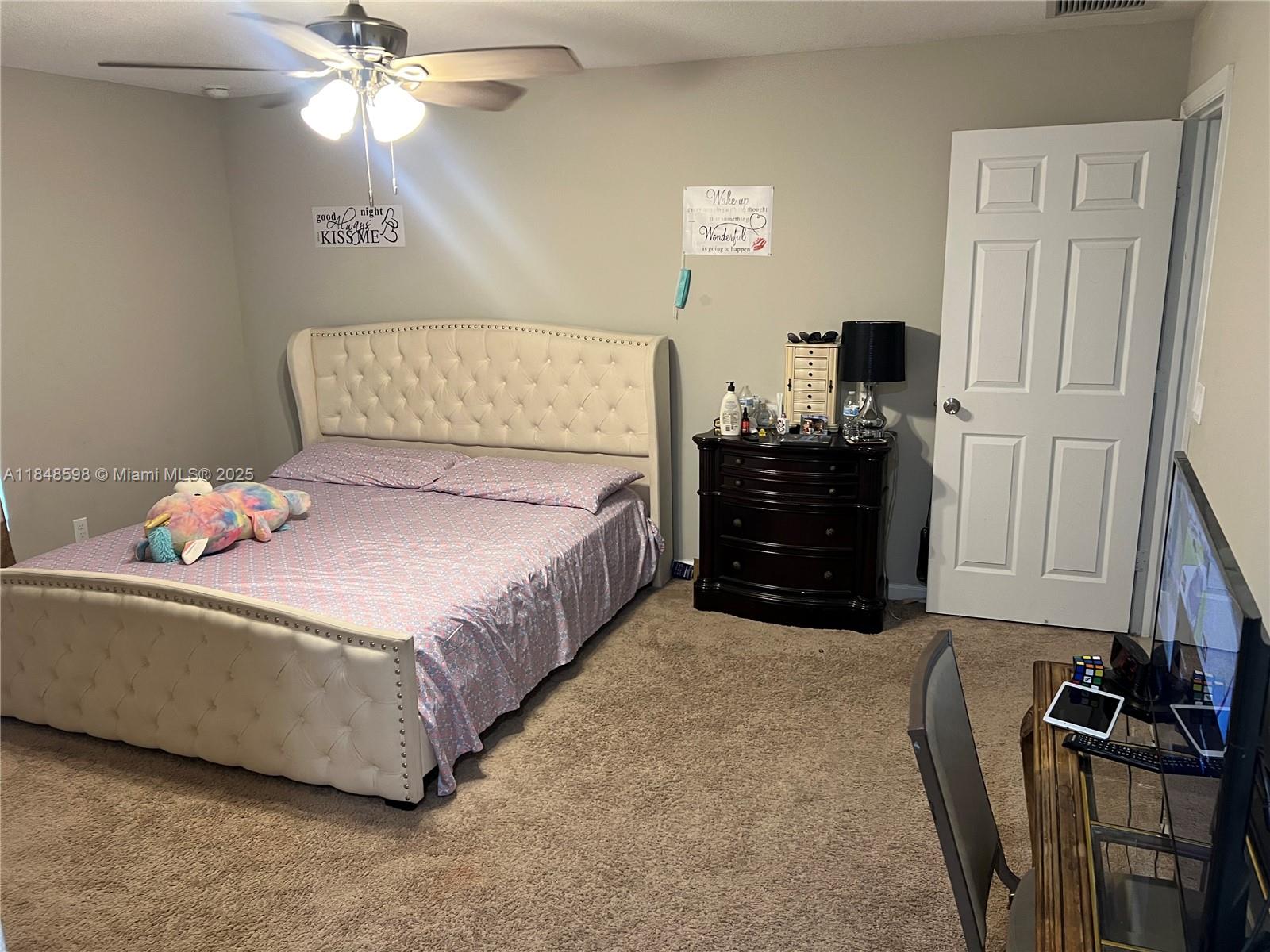 172 Southwest Langfield Avenue Port St. Lucie, FL 34984 - Photo 13 of 24 a bedroom with a bed and a mirror