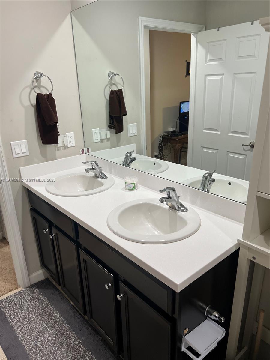 172 Southwest Langfield Avenue Port St. Lucie, FL 34984 - Photo 15 of 24 a bathroom with a sink and a mirror