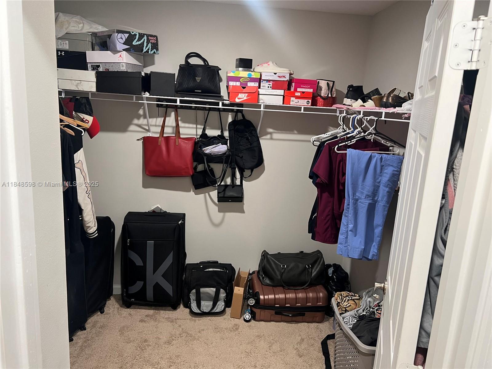 172 Southwest Langfield Avenue Port St. Lucie, FL 34984 - Photo 16 of 24 a view of walk in closet with clothes and shoes