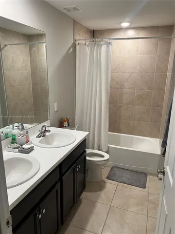 a bathroom with a double vanity sink toilet and shower
