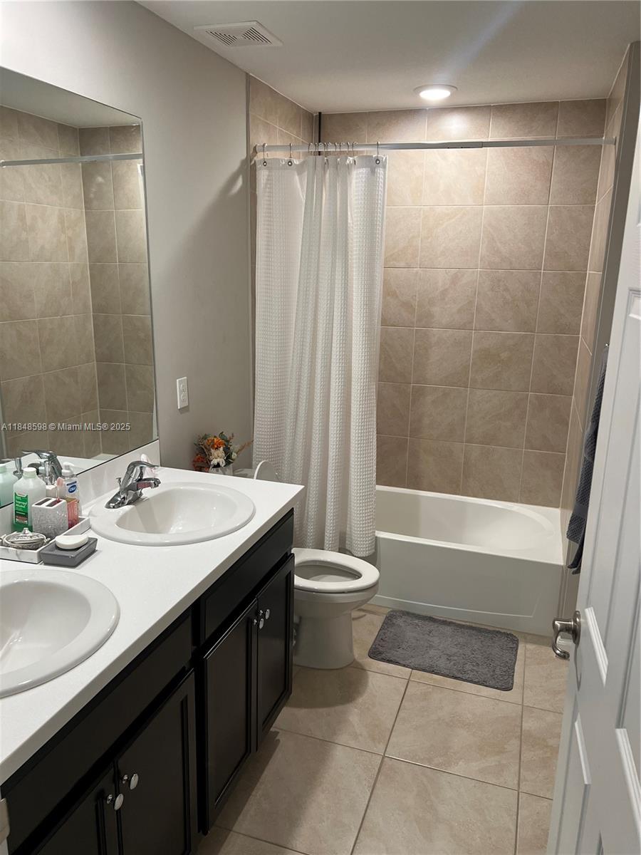 172 Southwest Langfield Avenue Port St. Lucie, FL 34984 - Photo 19 of 24 a bathroom with a double vanity sink toilet and shower