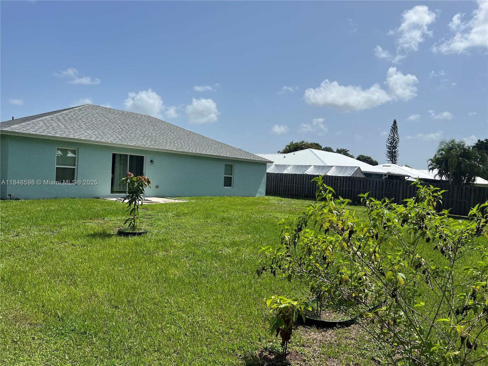 172 Southwest Langfield Avenue Port St. Lucie, FL 34984 - Photo 24 of 24 a front view of a house with a garden and yard