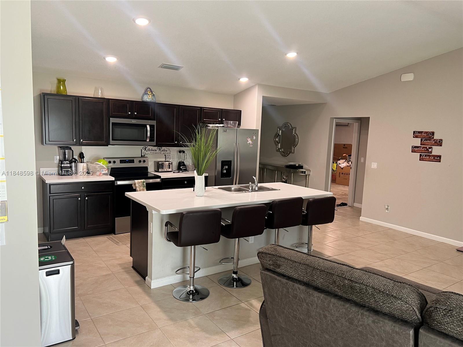 172 Southwest Langfield Avenue Port St. Lucie, FL 34984 - Photo 6 of 24 a kitchen with a sink stainless steel appliances and cabinets