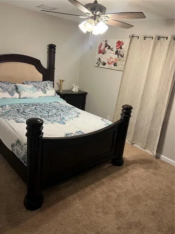 a bedroom with a bed and a mirror on the dresser