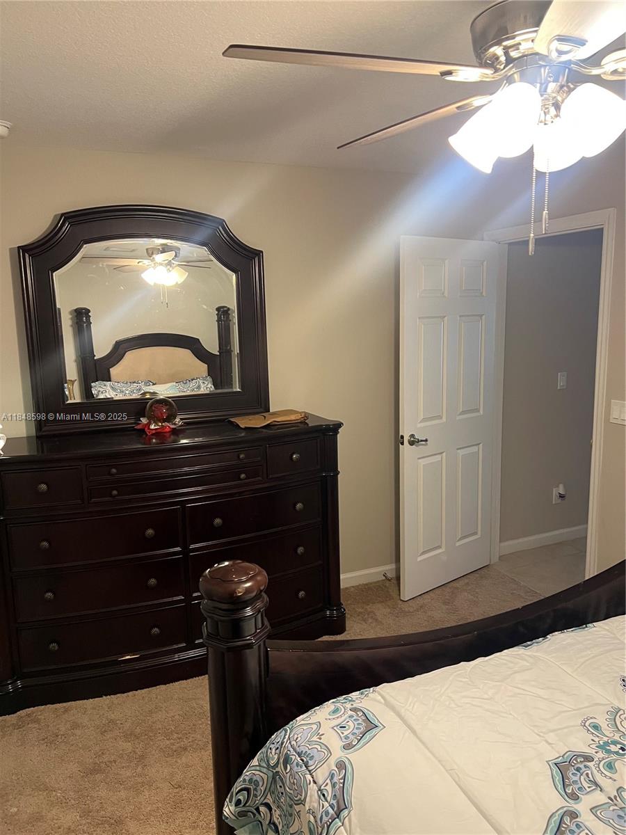 172 Southwest Langfield Avenue Port St. Lucie, FL 34984 - Photo 10 of 24 a bedroom with a bed and a mirror on the dresser
