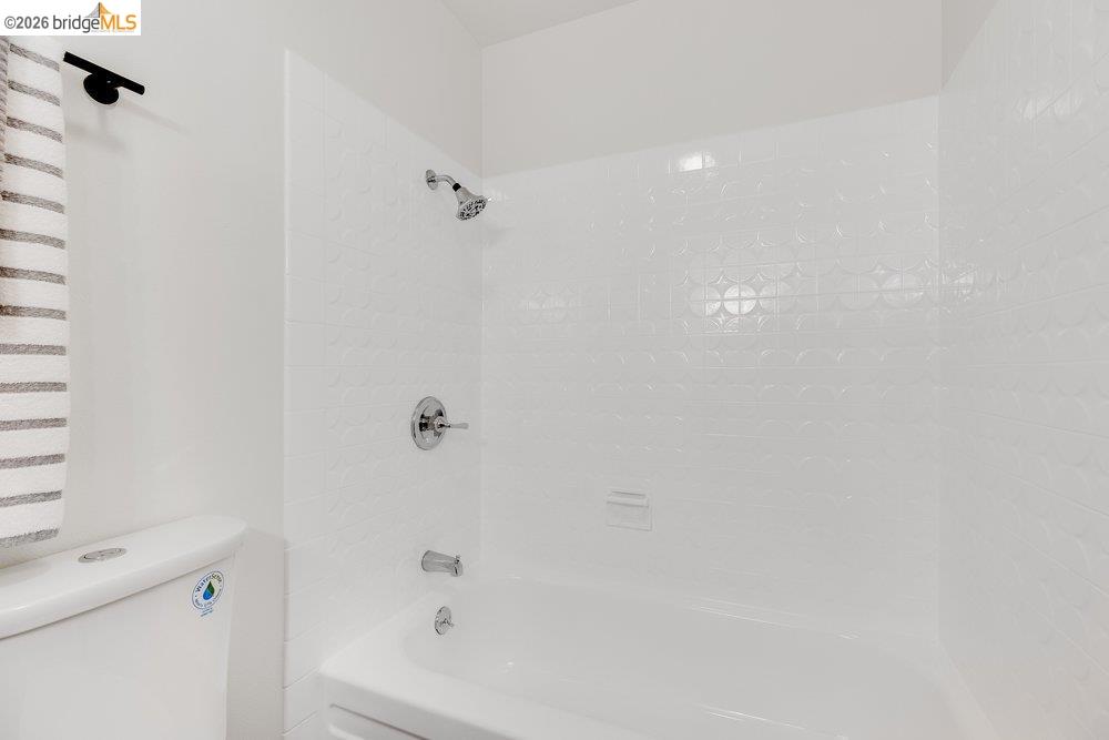 1298 Ribbon Street Foster City, CA 94404 - Photo 56 of 86 White bathtub with chrome fixtures and embossed tile surround