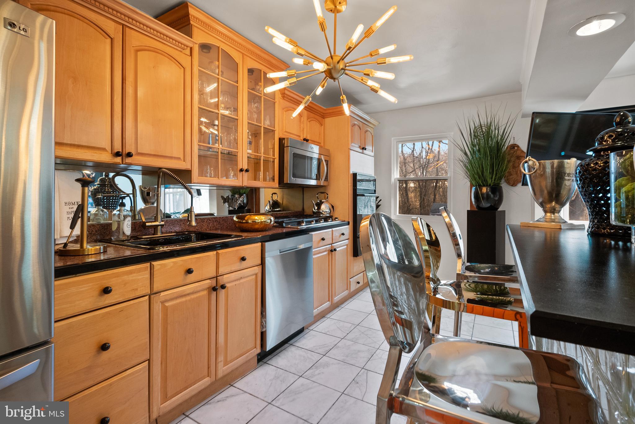 2737 East Country Club Road Philadelphia, PA 19131 - Photo 16 of 24 a kitchen with stainless steel appliances granite countertop a stove a sink a dining table and chairs