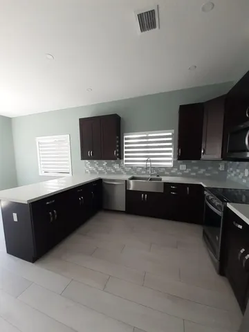 a large kitchen with a large counter top a sink and a stove