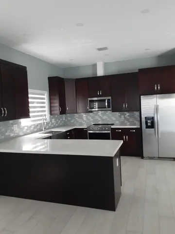 a kitchen with stainless steel appliances granite countertop a sink a stove a microwave a counter top and oven