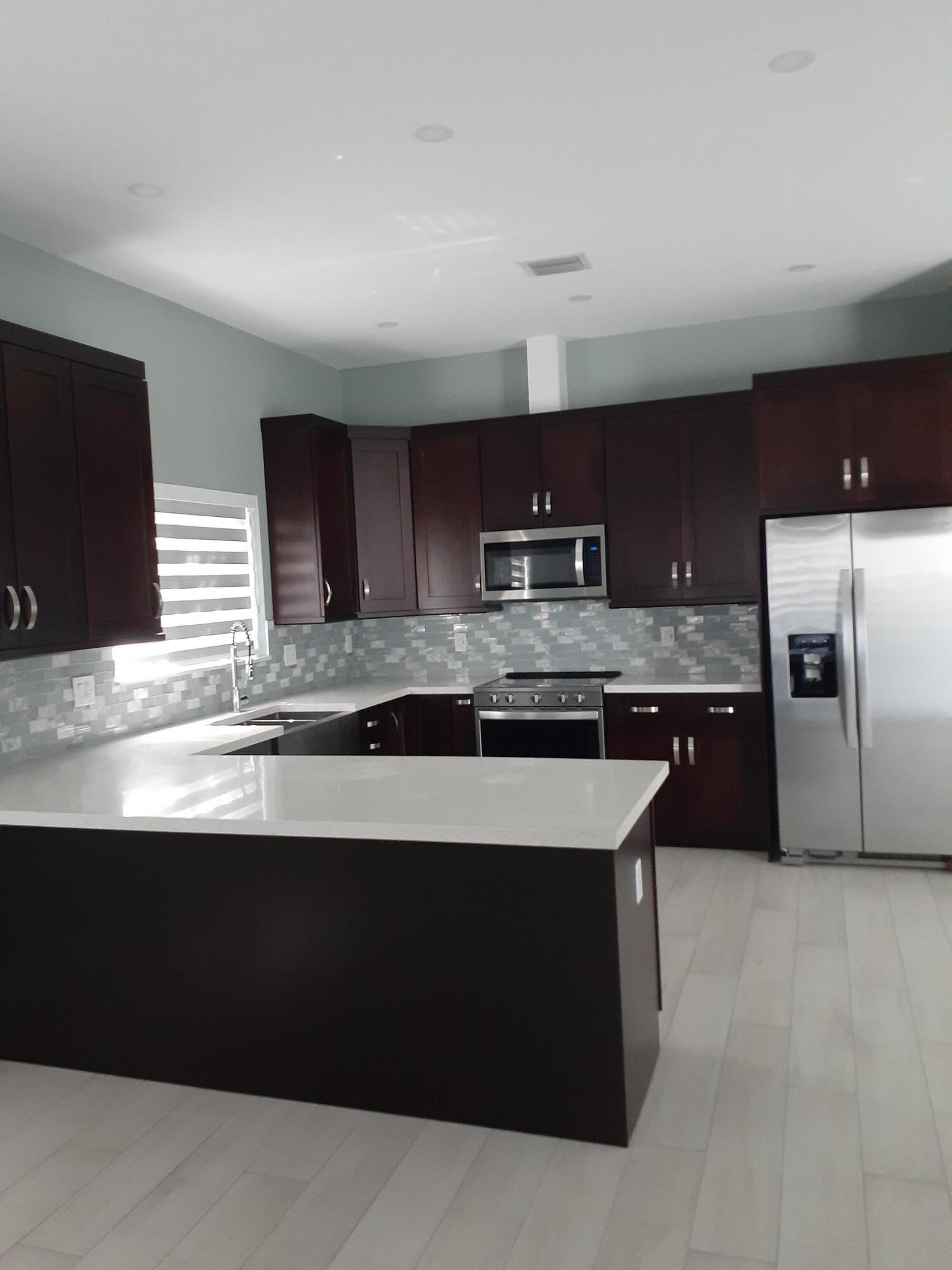 23 Jenny Lane Key Largo, FL 33037 - Photo 8 of 38 a kitchen with stainless steel appliances granite countertop a sink a stove a microwave a counter top and oven