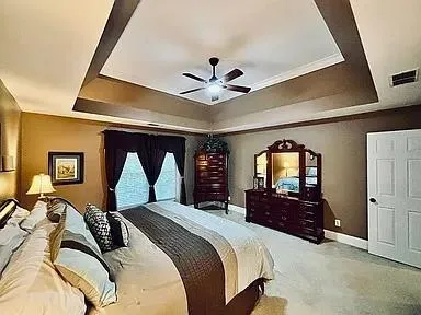 a bedroom with a bed window and dresser