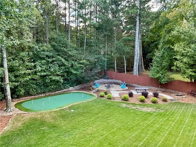 a view of a swimming pool with lawn chairs under an umbrella