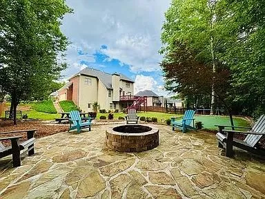 a view of a backyard with table and chairs and a barbeque