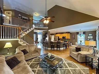 a living room with furniture ceiling fan and a rug
