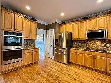 a kitchen with granite countertop a refrigerator stove and microwave