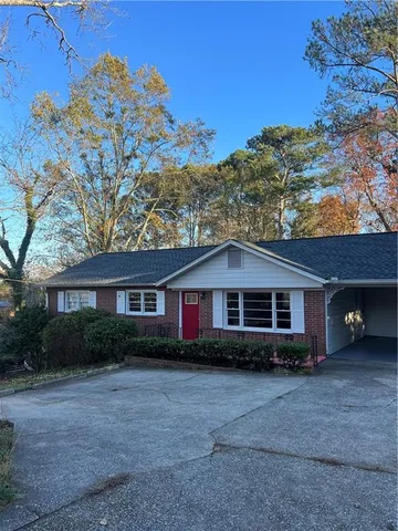 a front view of a house with a yard and trees