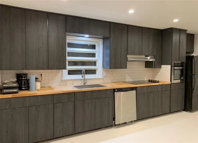 a kitchen with stainless steel appliances granite countertop wooden cabinets a sink and dishwasher