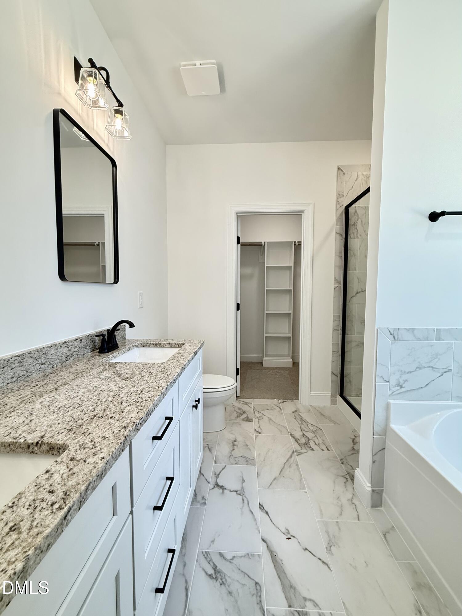 10300 Stallings Road Spring Hope, NC 27882 - Photo 21 of 36 a spacious bathroom with a granite countertop sink and a mirror