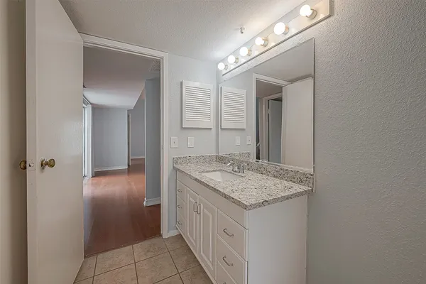 a bathroom with a granite countertop sink and a mirror