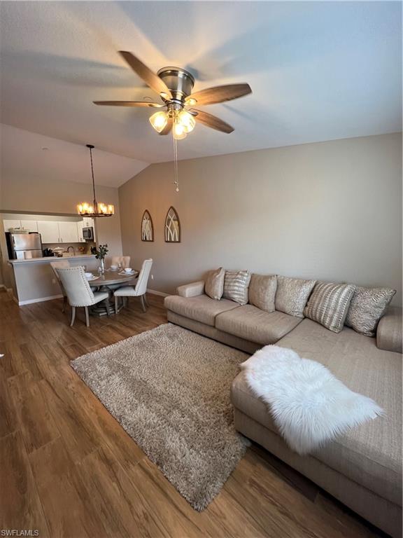 a living room with lots of furniture and a ceiling fan
