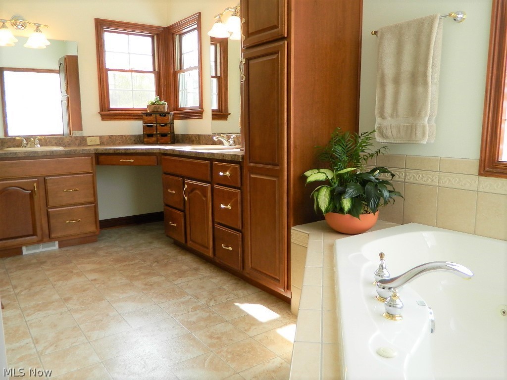 12395 Falcon Ridge Road Chesterland, OH 44026 - Photo 16 of 35 Elegant Owner's Suite with Two Sinks, Jetted Tub, and Adjacent 15x6' Carpeted Walk In Closet with Attic Access!