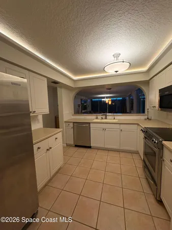a kitchen with a sink a stove top oven and cabinets
