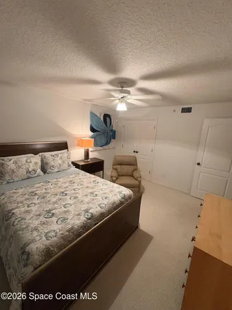 a large bed sitting in a bedroom and a chandelier