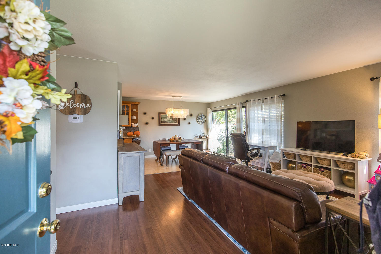 6542 Stoney View Lane, Unit 5 Simi Valley, CA 93063 - Photo 6 of 32 a living room with furniture a flat screen tv and a floor to ceiling window