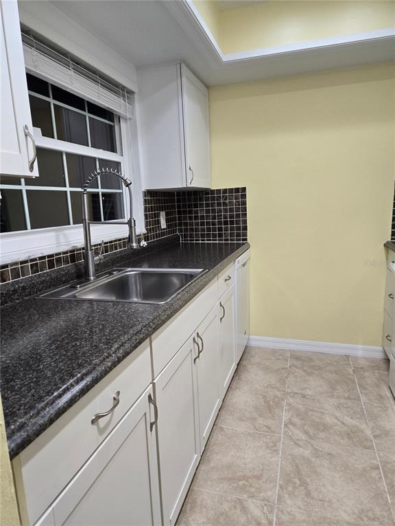 1701 Pinehurst Road, Unit 3E Dunedin, FL 34698 - Photo 8 of 10 a kitchen with granite countertop a sink and white cabinets