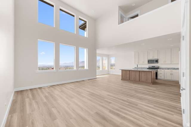 1510 West 600 North, Unit GE 04 Mapleton, UT 84664 - Photo 7 of 21 Two-story living area with high ceilings, wood-finish flooring, and a bank of six large windows