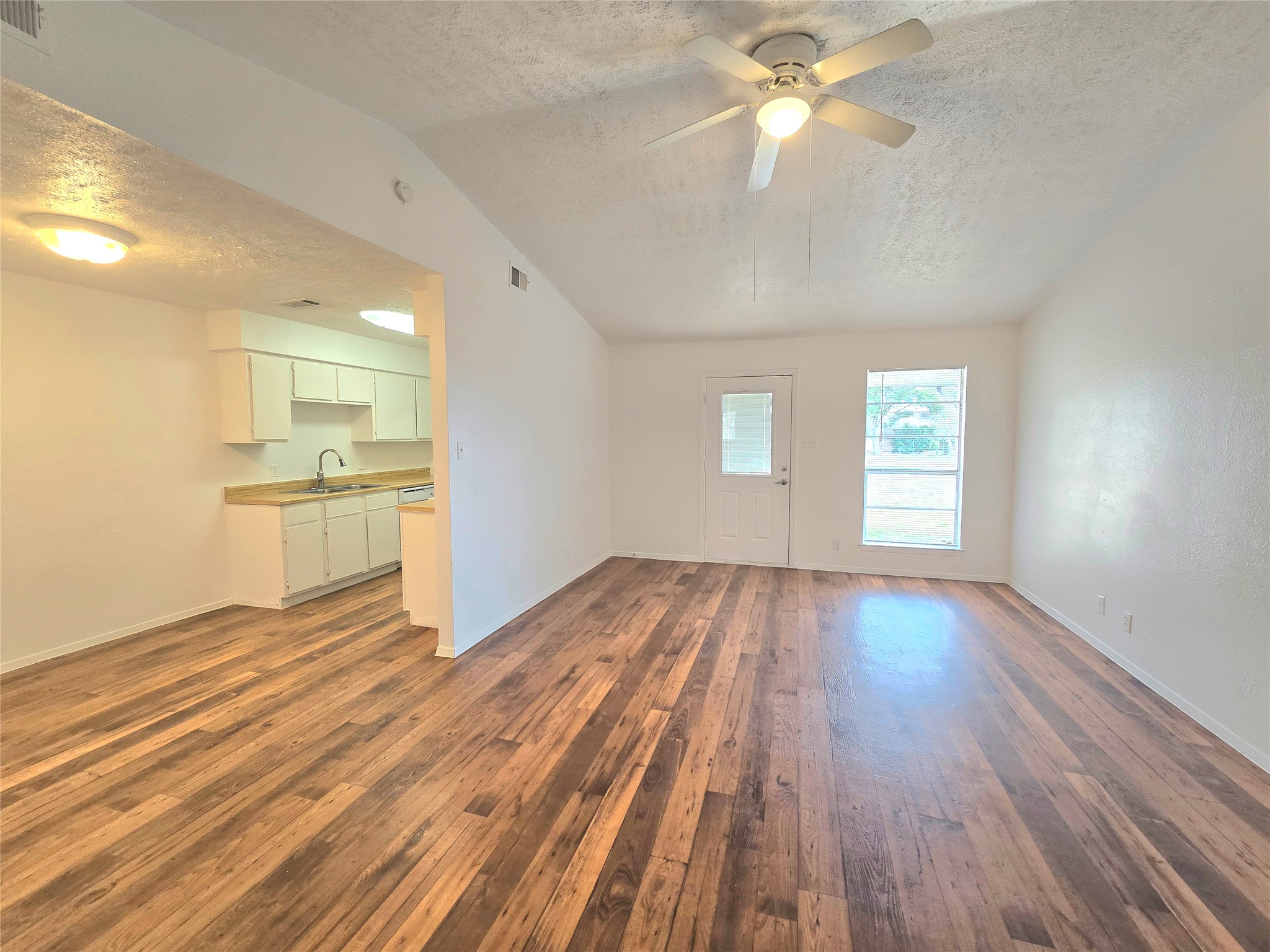 15208 Spring Hill Lane, Unit A Pflugerville, TX 78660 - Photo 4 of 16 Spacious living area featuring wood-finish flooring, vaulted ceilings, and a ceiling fan