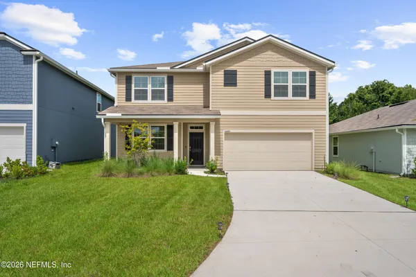 a front view of a house with a yard and garage