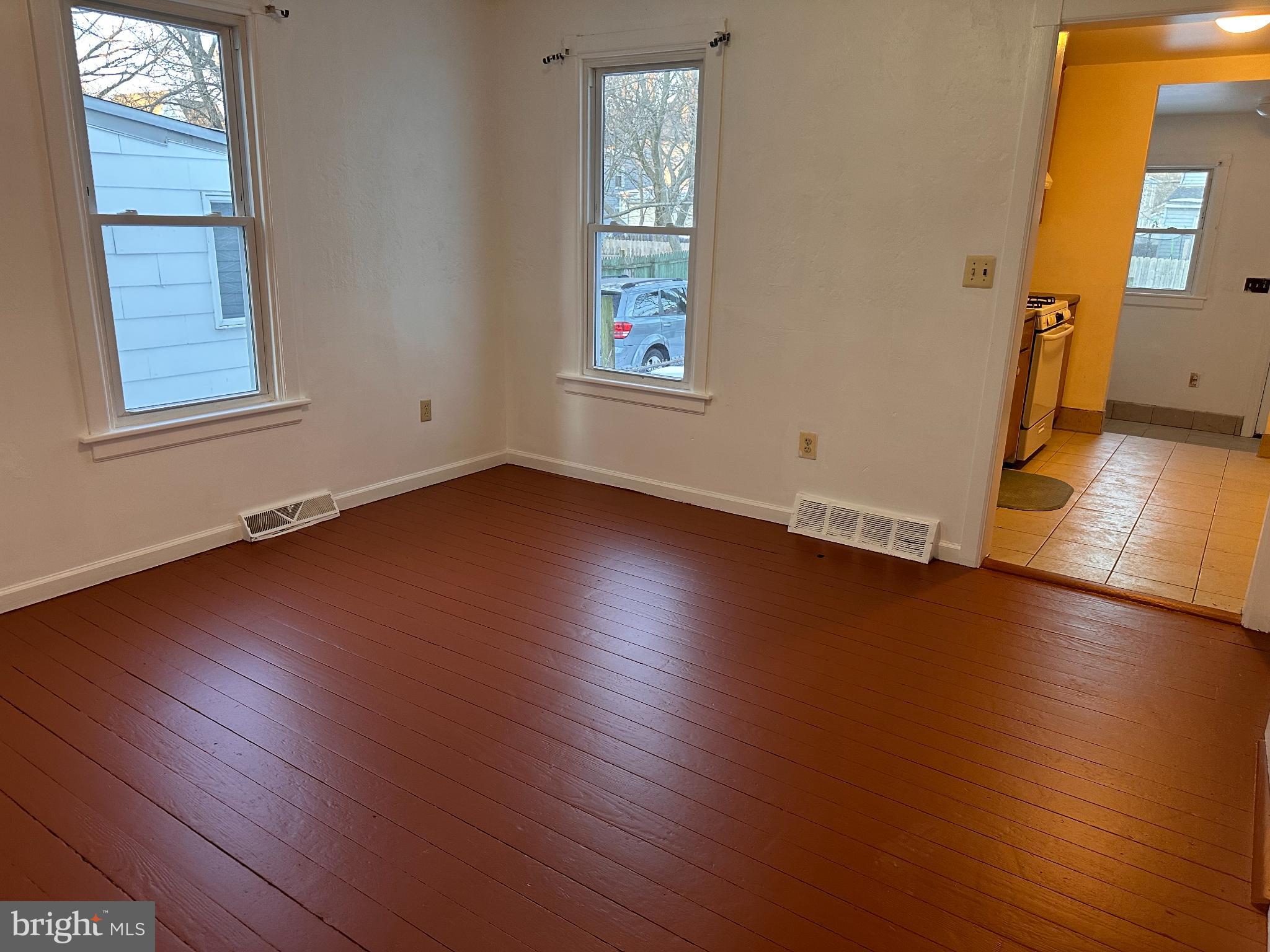 317 South 3rd Street Millville, NJ 08332 - Photo 4 of 8 an empty room with wooden floor and windows