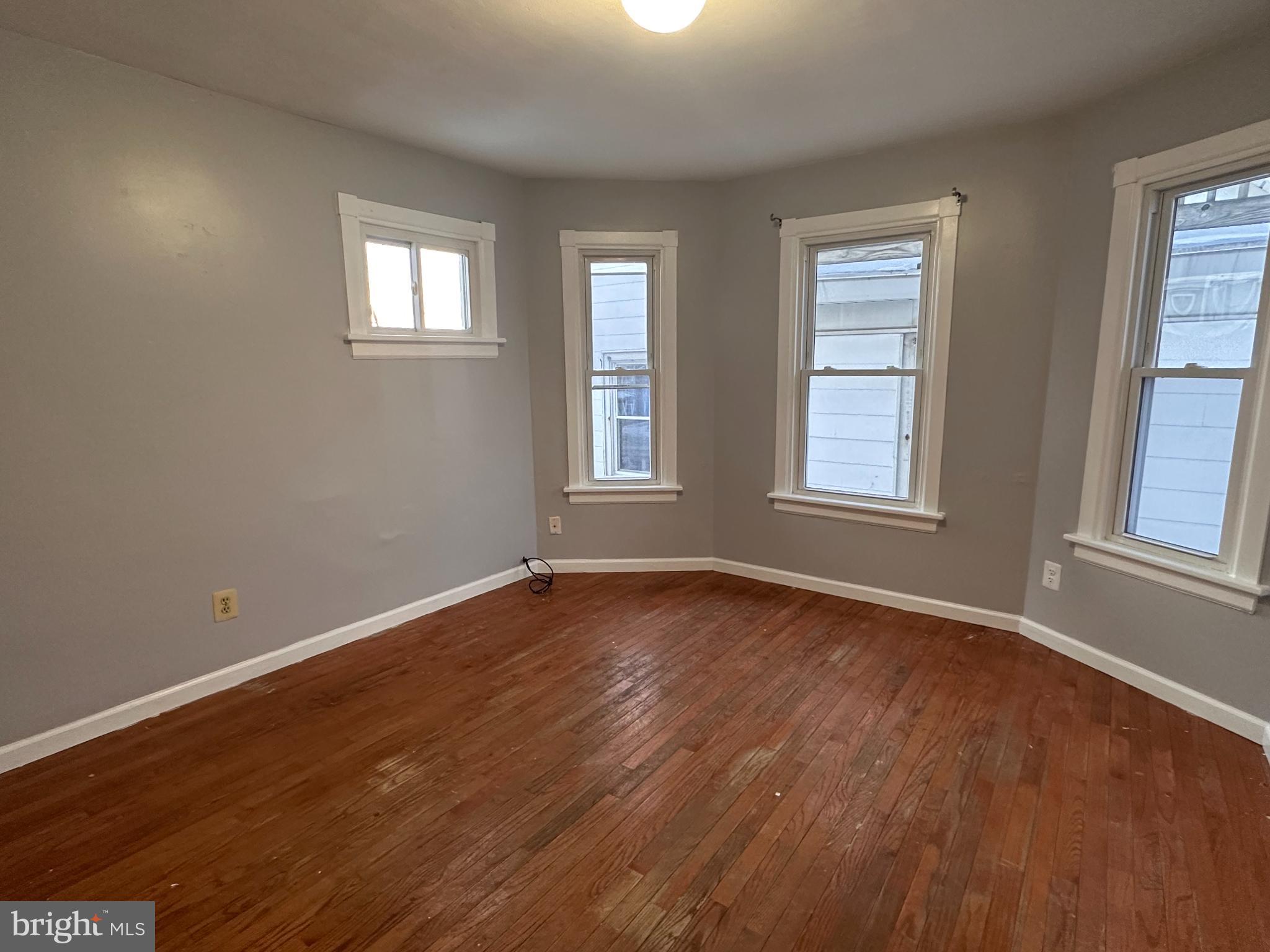 317 South 3rd Street Millville, NJ 08332 - Photo 5 of 8 an empty room with wooden floor and windows