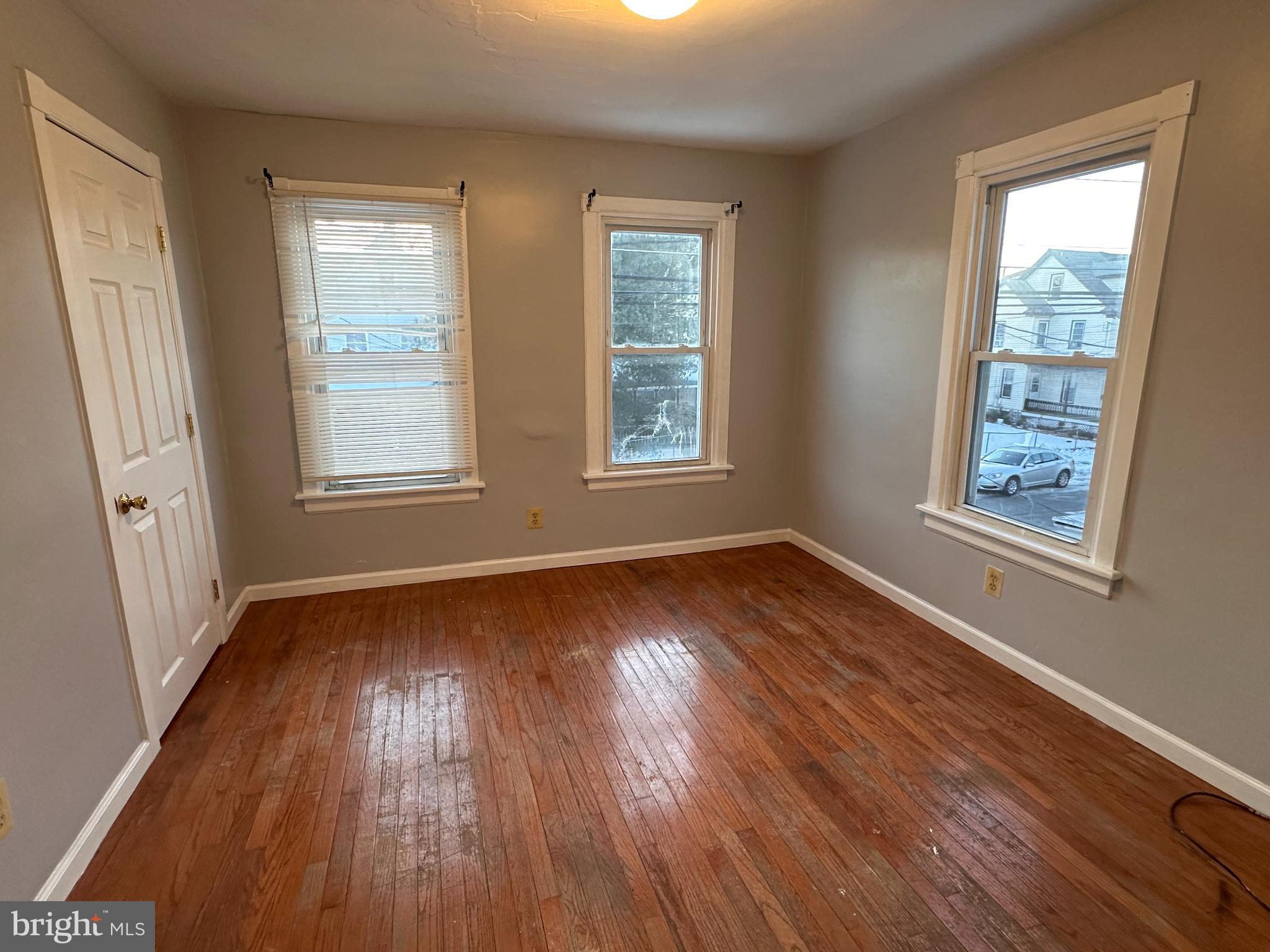 317 South 3rd Street Millville, NJ 08332 - Photo 6 of 8 an empty room with wooden floor and windows