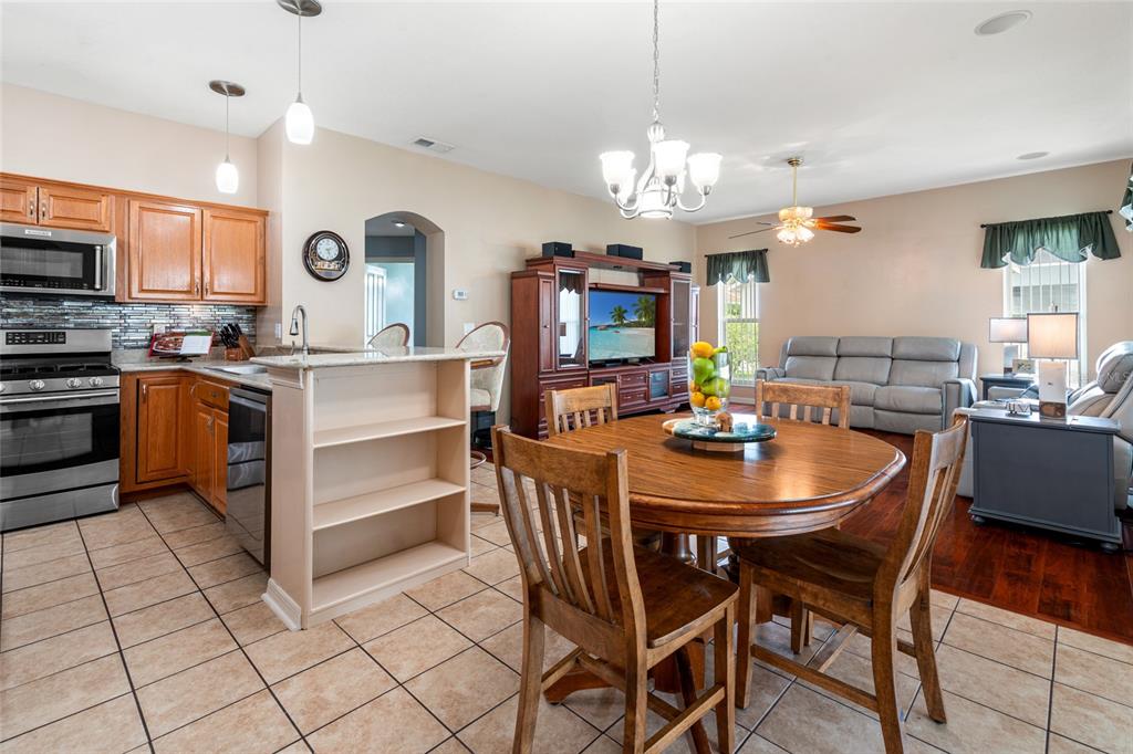 28390 Openfield Loop Wesley Chapel, FL 33543 - Photo 15 of 44 a kitchen with a dining table and chairs