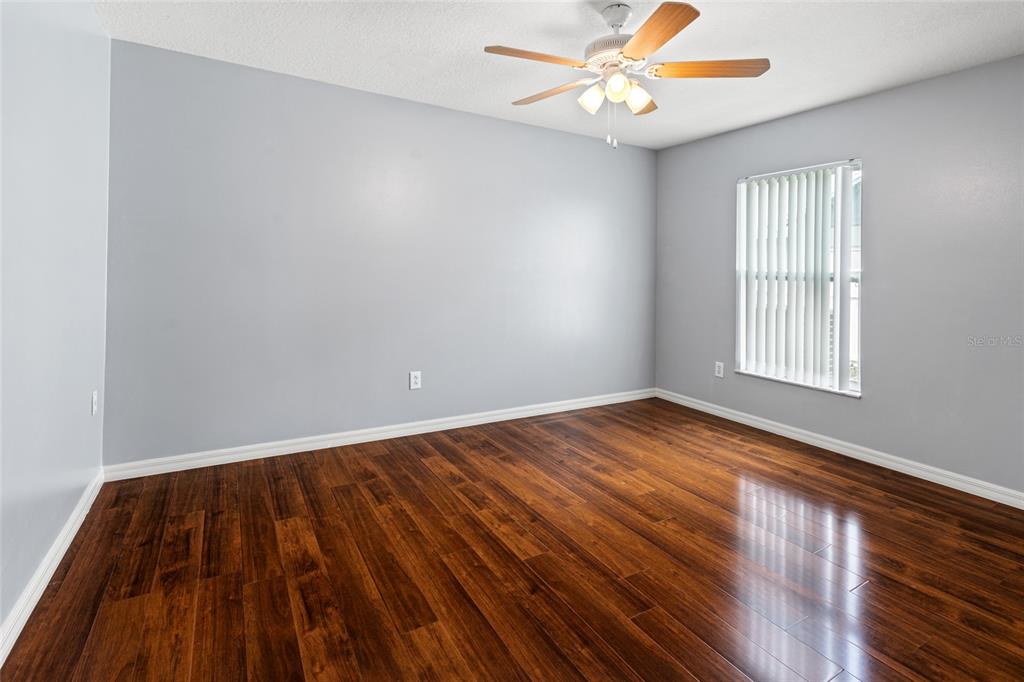 28390 Openfield Loop Wesley Chapel, FL 33543 - Photo 20 of 44 an empty room with wooden floor fan and windows