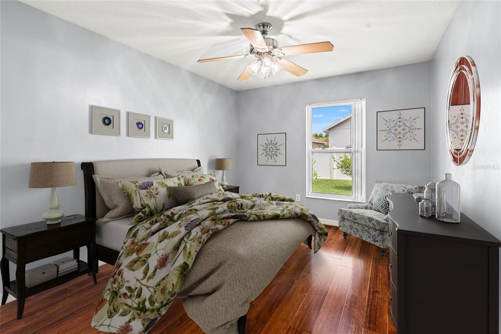 28390 Openfield Loop Wesley Chapel, FL 33543 - Photo 22 of 44 a bed sitting in a bedroom next to a window with wooden floor