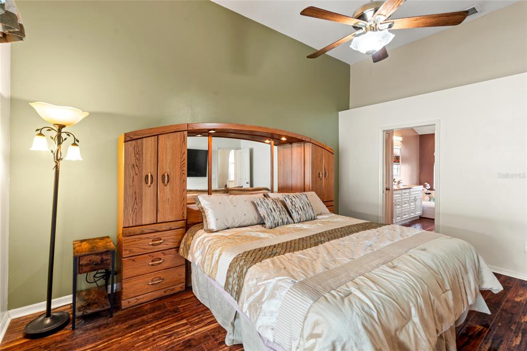 28390 Openfield Loop Wesley Chapel, FL 33543 - Photo 9 of 44 a bedroom with a bed and a chandelier