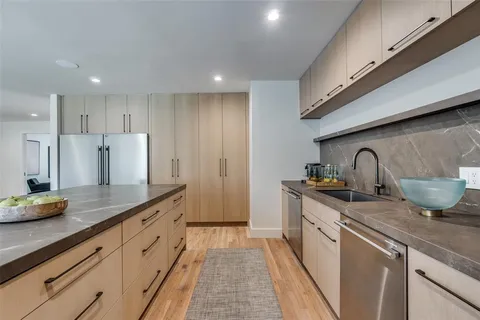 a kitchen with sink a stove and cabinets