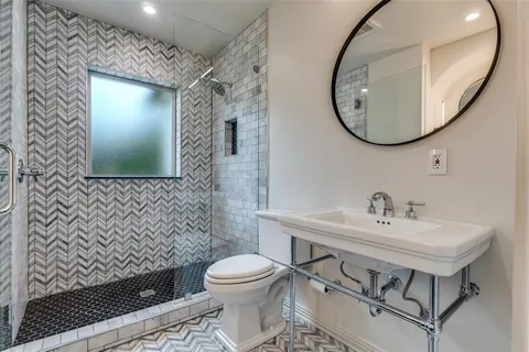a bathroom with a sink mirror and toilet