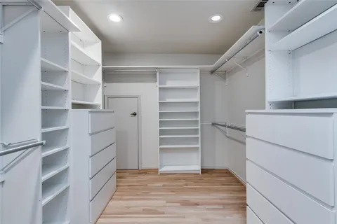a view of walk in closet with empty racks