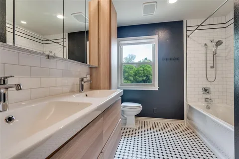 a bathroom with a bathtub a sink a toilet and a shower