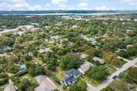 an aerial view of residential houses with outdoor space and trees