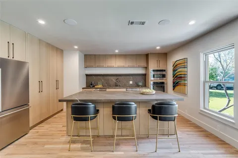 a kitchen with a stove a refrigerator and a dining table