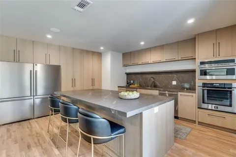 a kitchen with stainless steel appliances granite countertop a sink stove and refrigerator