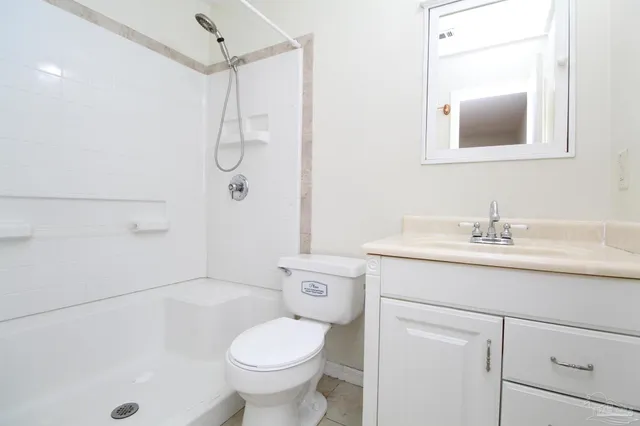 a bathroom with a granite countertop sink a toilet and shower