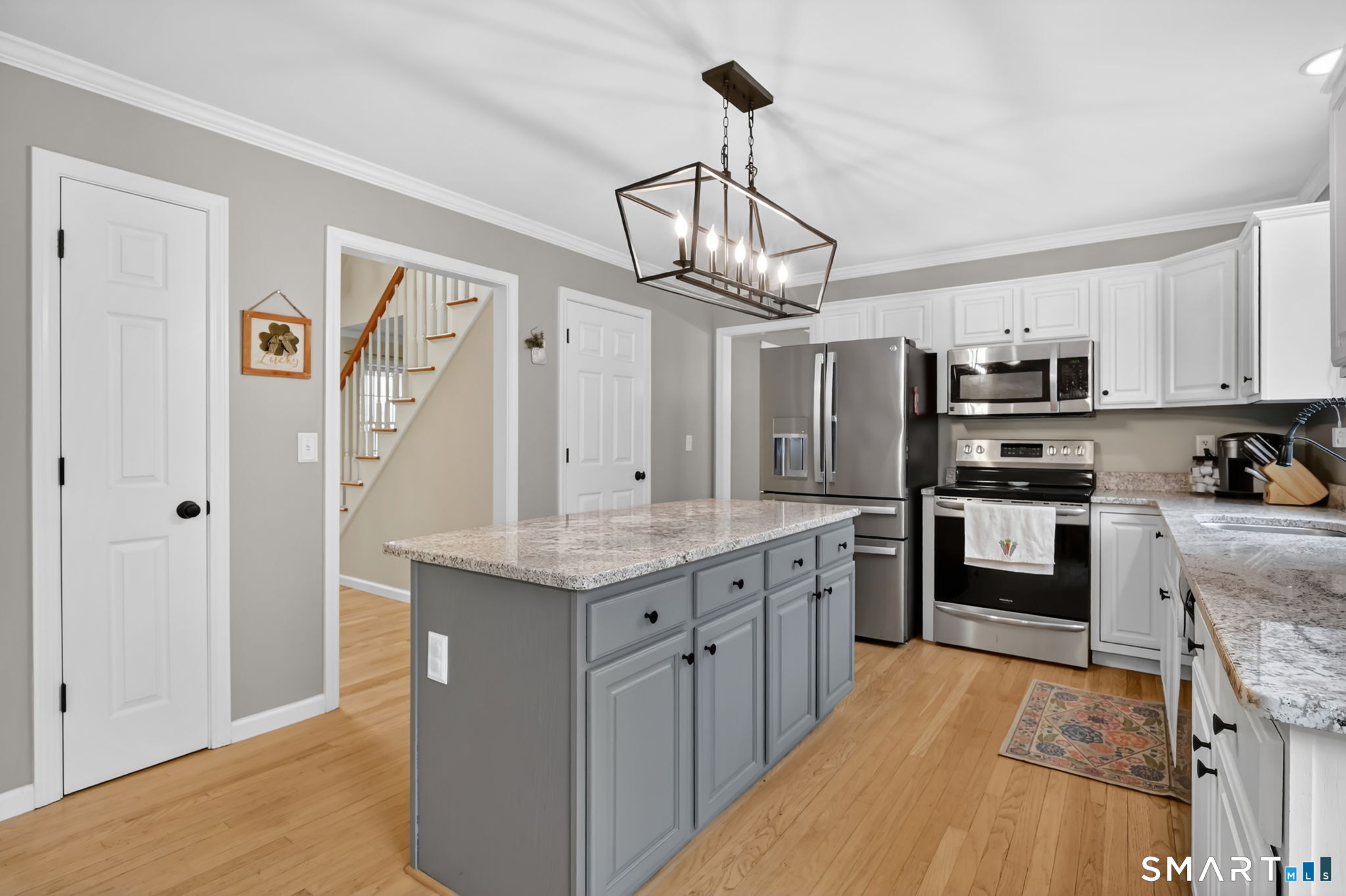 5 Tuckers Run Ledyard, CT 06339 - Photo 18 of 39 a kitchen with stainless steel appliances granite countertop a refrigerator a stove oven a sink dishwasher and white cabinets with wooden floor