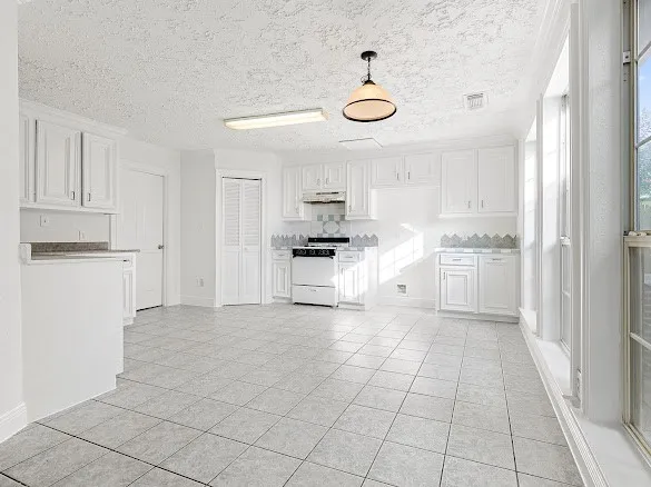 a view of kitchen with granite countertop cabinets and window